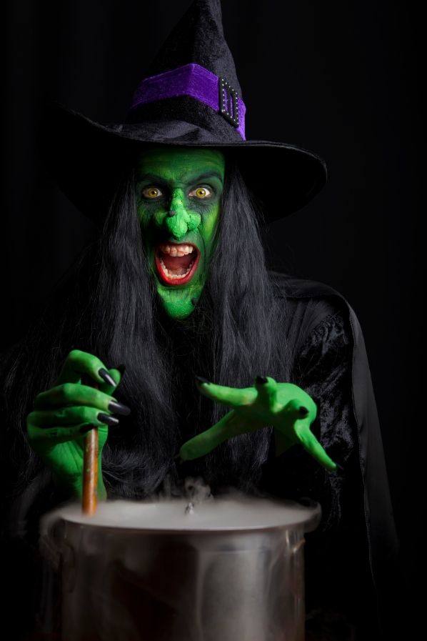 Scary witch stirring a smoky cauldron.